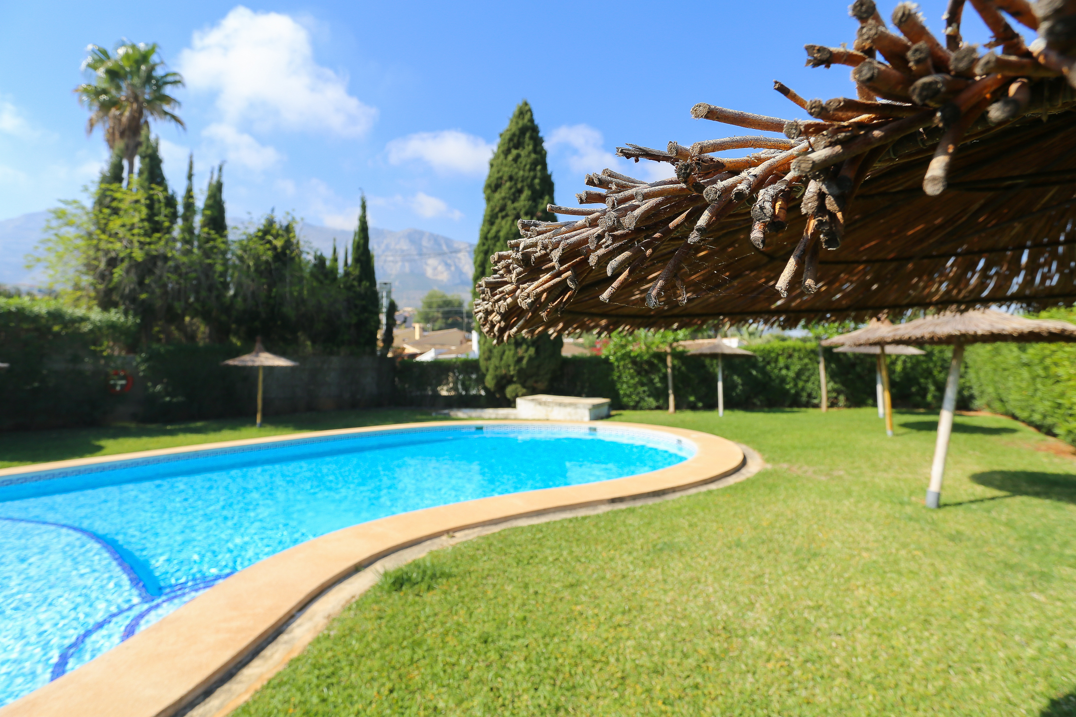 Zona de piscina con tumbonas en el apartamento Montesol en Dénia